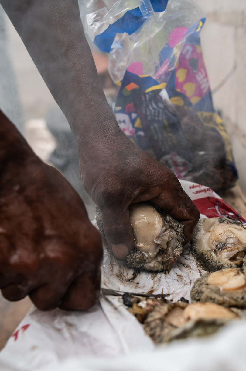 A resident of Hangberg in the Western Cape prepares abalone for the pot.
