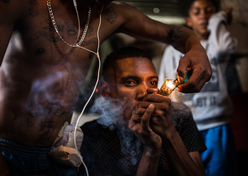 Members of the Young Gifted Bastards gang smoke a bottleneck pipe in Blikkiesdorp, Cape Town.
