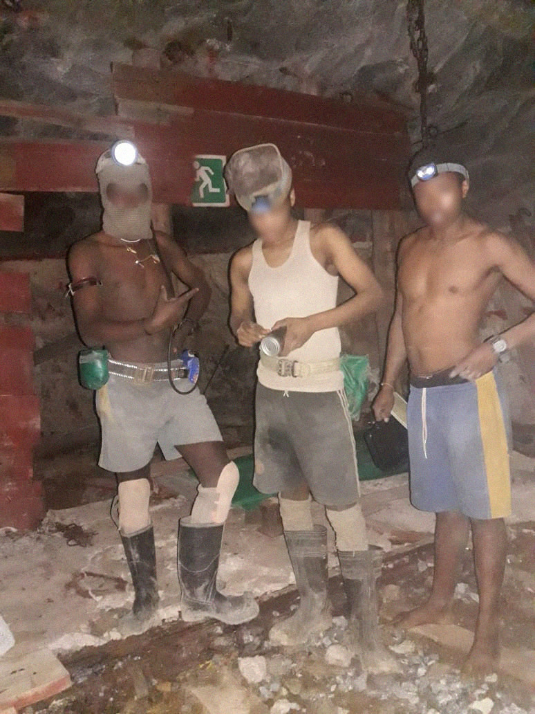 Three suspected illegal miners equipped with flashlights in a mineshaft, 2020.
