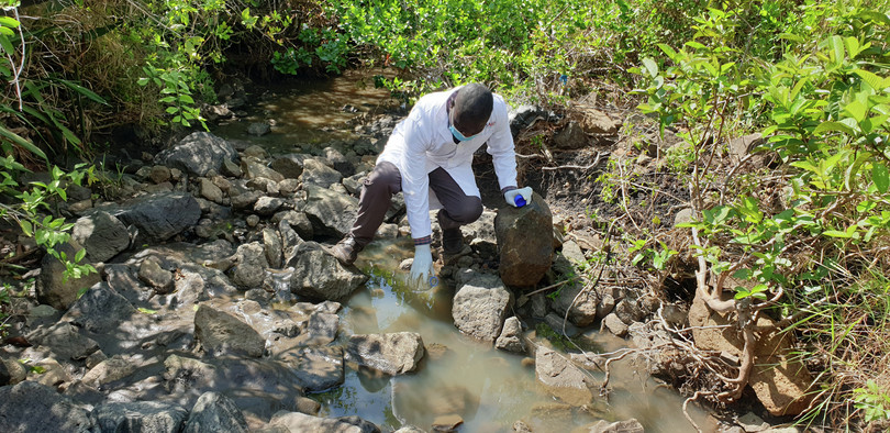 A Kenyan government official collects a water sample in Kowuor village, Migori county, September 2021. Residents believe that the sudden deaths of several livestock can be linked to a nearby gold-leaching site and the use of sodium cyanide.
